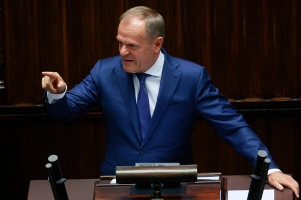 Donald Tusk przemawiający na mównicy.