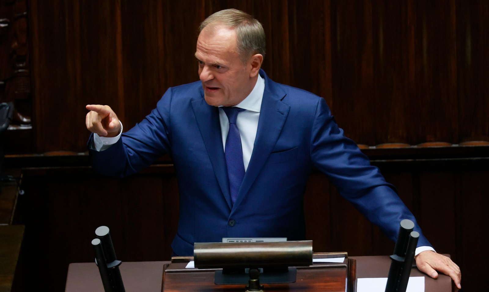 Donald Tusk przemawiający na mównicy.